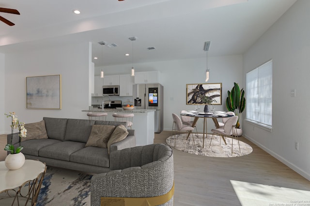 living room with ceiling fan and light hardwood / wood-style floors