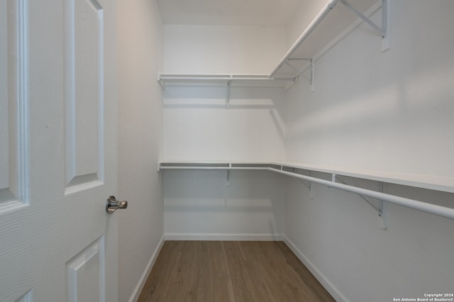 walk in closet with hardwood / wood-style floors