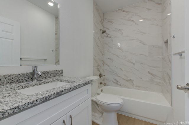 full bathroom with hardwood / wood-style floors, tiled shower / bath combo, vanity, and toilet