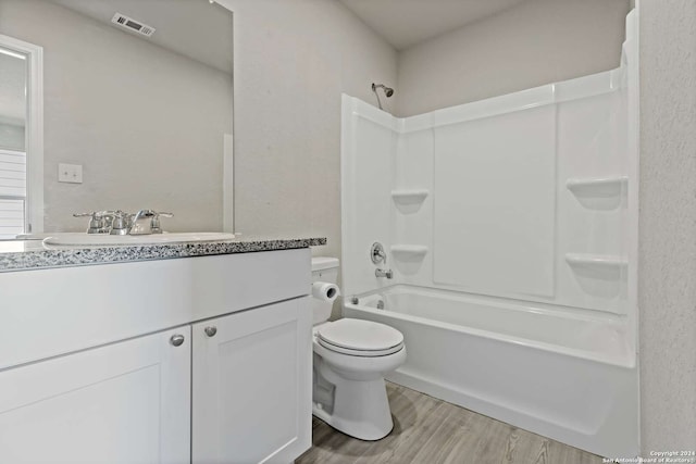 full bathroom with vanity, bathtub / shower combination, toilet, and hardwood / wood-style flooring