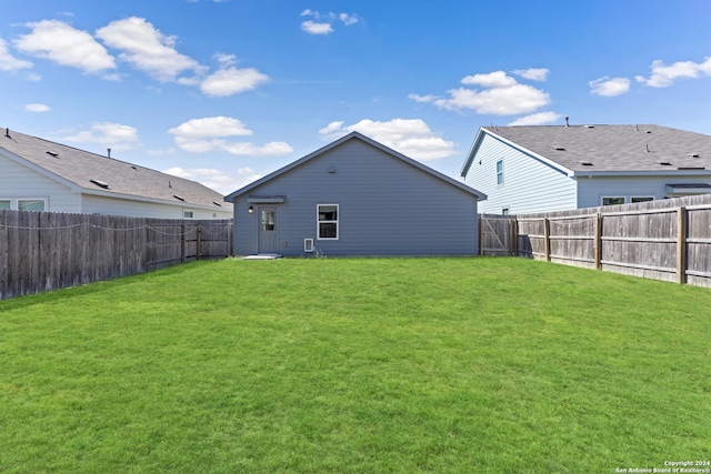 rear view of property featuring a yard