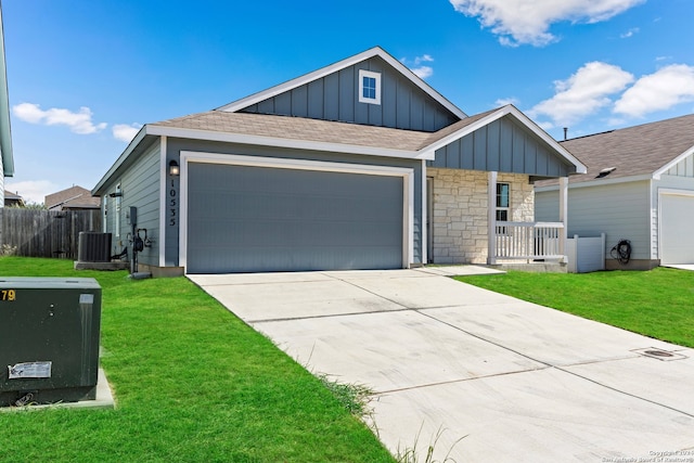 view of front of house with a garage, a front lawn, and central AC