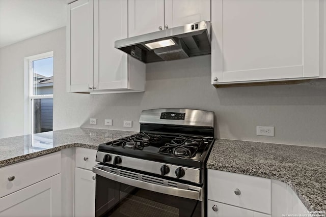 kitchen with light stone counters, white cabinets, and gas range