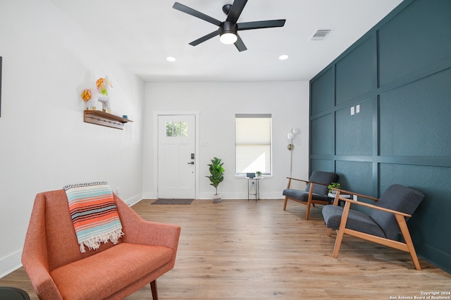 living area with light wood-type flooring and ceiling fan