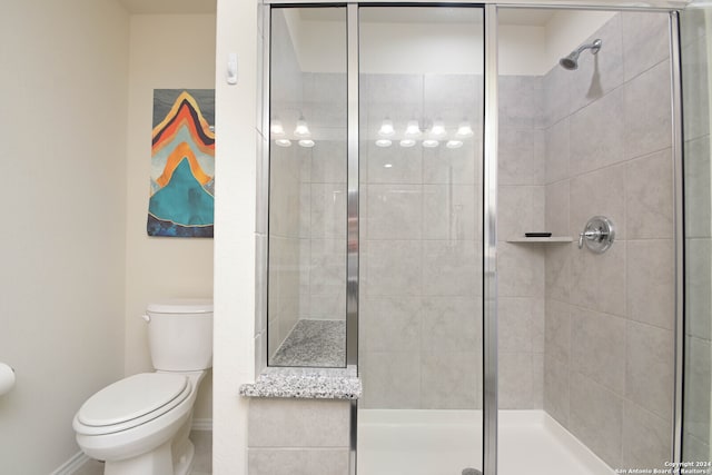 bathroom with a shower with door and toilet