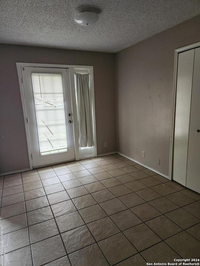 entryway with tile patterned flooring and a textured ceiling