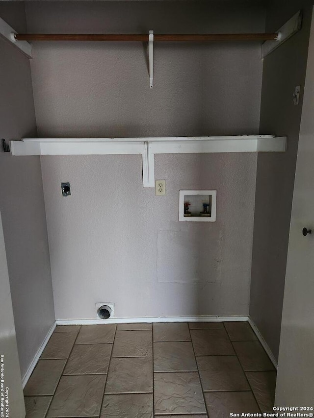 washroom with electric dryer hookup, hookup for a washing machine, and dark tile patterned flooring