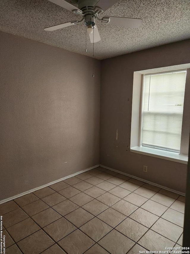 unfurnished room with light tile patterned floors, a textured ceiling, and ceiling fan