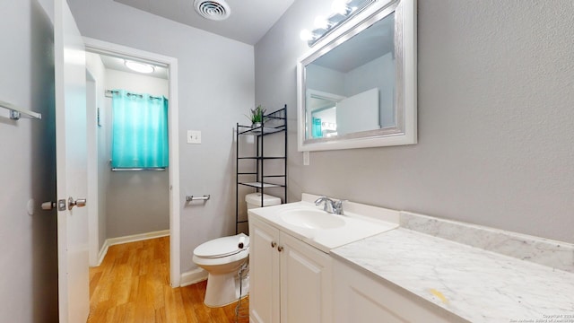 bathroom featuring vanity, toilet, and hardwood / wood-style flooring