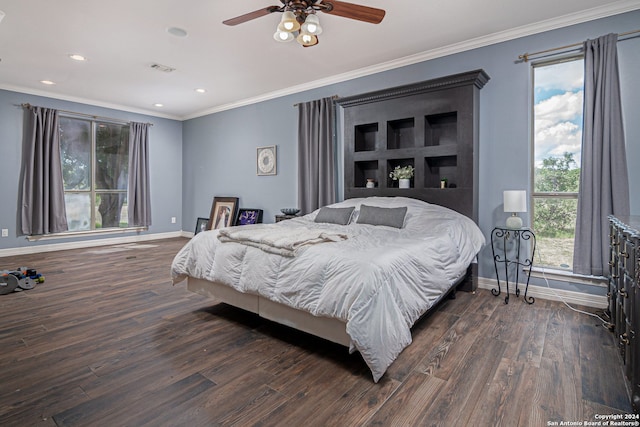 bedroom featuring dark hardwood / wood-style floors, ornamental molding, and multiple windows