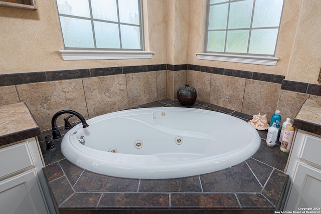 bathroom featuring a bathing tub, vanity, and a wealth of natural light