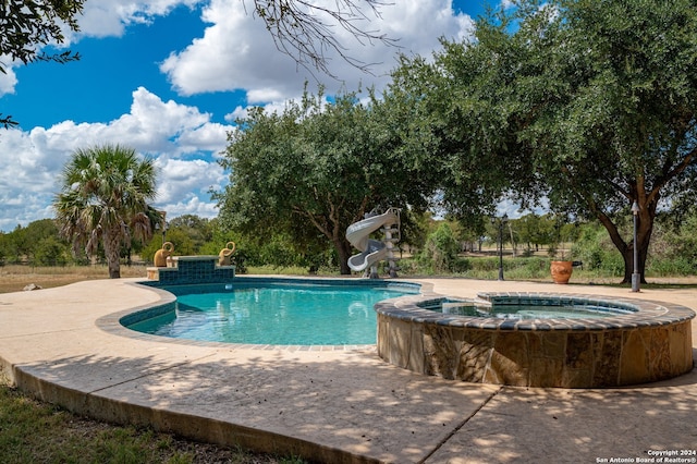 view of pool featuring a patio, an in ground hot tub, and a water slide