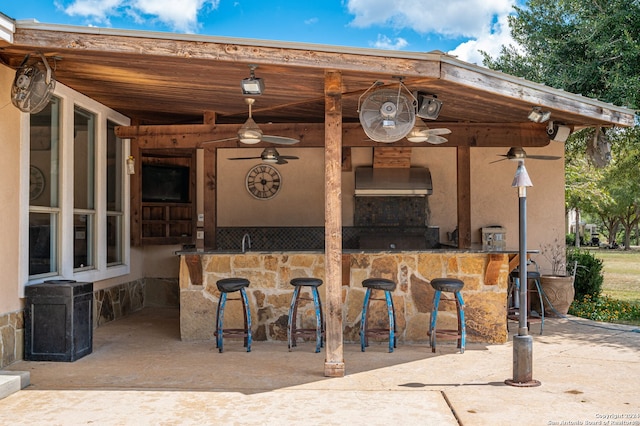 view of patio / terrace with ceiling fan and a bar