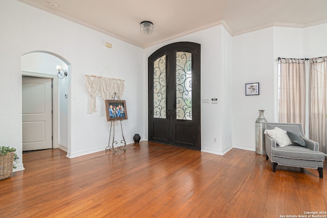 foyer with wood-type flooring, ornamental molding, and french doors