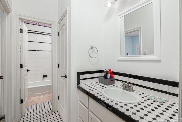 bathroom with backsplash, vanity, and tiled shower / bath combo