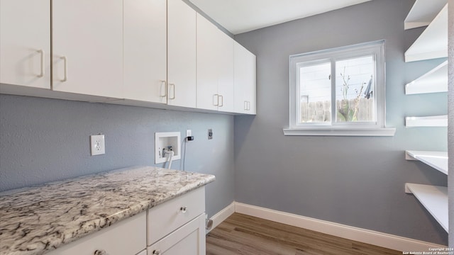 clothes washing area featuring light hardwood / wood-style floors, hookup for an electric dryer, washer hookup, and cabinets