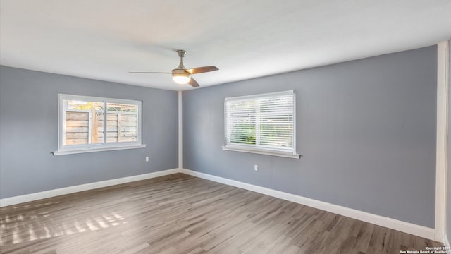 spare room with ceiling fan, light hardwood / wood-style floors, and a healthy amount of sunlight