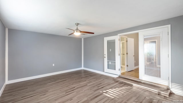 spare room featuring wood-type flooring, ceiling fan, and french doors