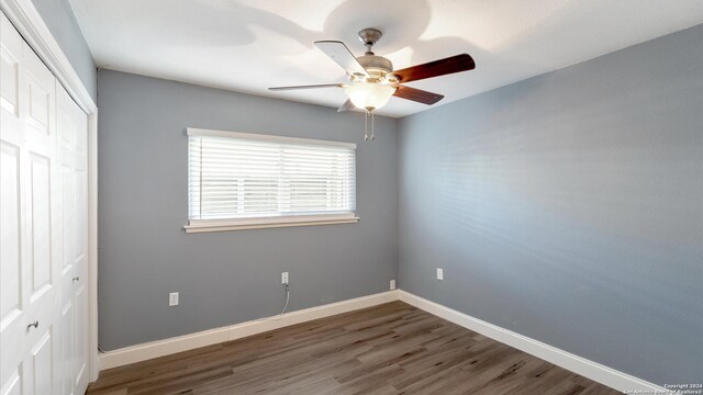 unfurnished bedroom with ceiling fan, a closet, and dark hardwood / wood-style flooring