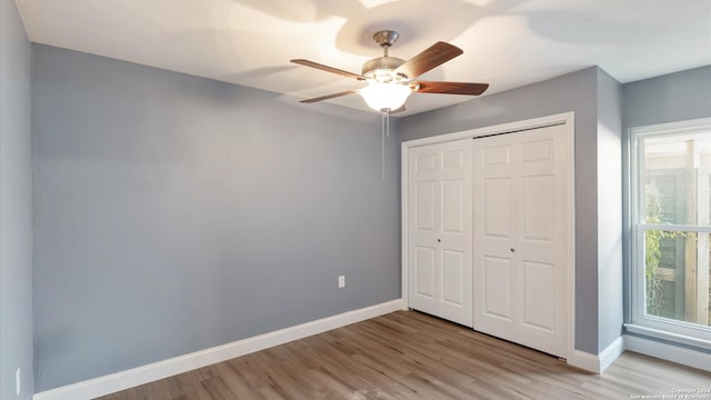 unfurnished bedroom featuring ceiling fan, light wood-type flooring, and a closet