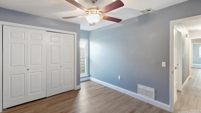 unfurnished bedroom featuring light wood-type flooring, ceiling fan, and a closet