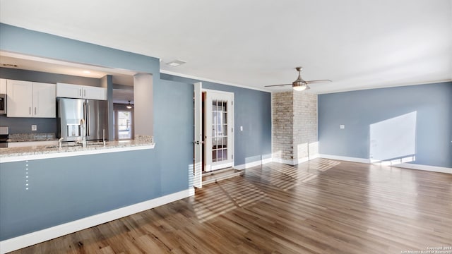 unfurnished living room featuring ceiling fan, hardwood / wood-style floors, and crown molding