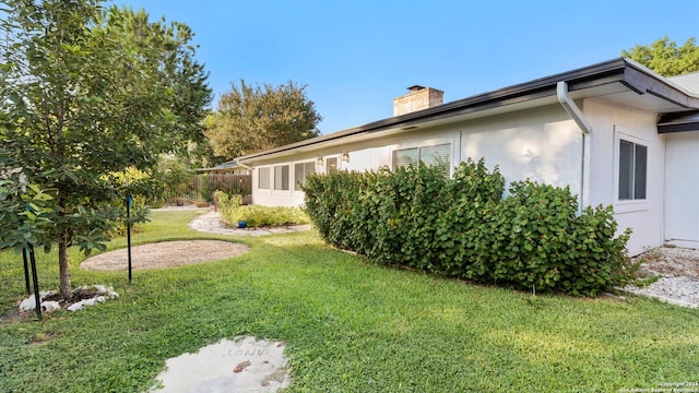 view of side of home with a lawn