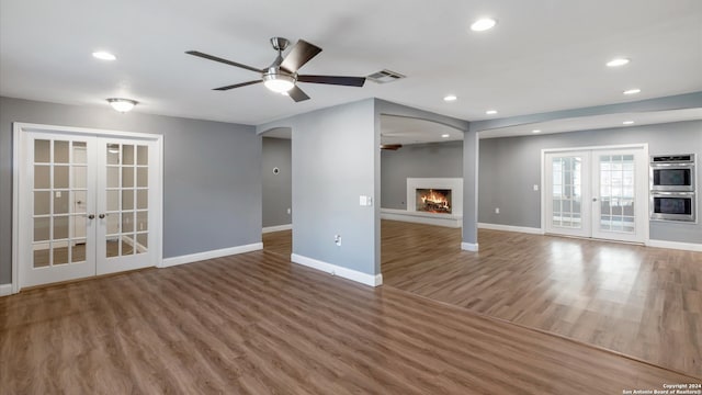 unfurnished living room featuring french doors, dark hardwood / wood-style flooring, and ceiling fan