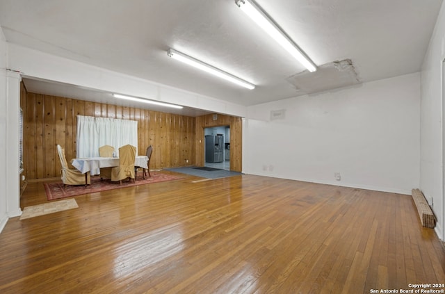 empty room with wooden walls and hardwood / wood-style flooring