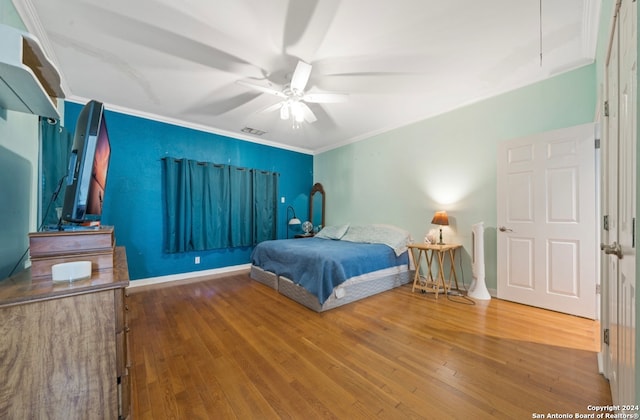 bedroom featuring ceiling fan, crown molding, and hardwood / wood-style floors