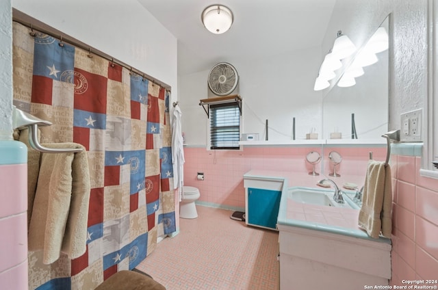 bathroom featuring vanity, tile walls, and toilet