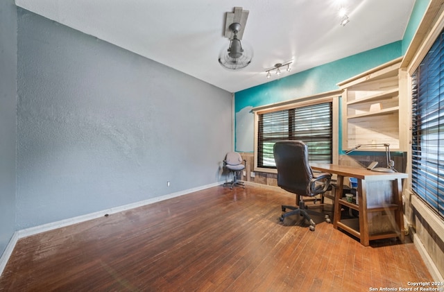 home office with track lighting and hardwood / wood-style floors