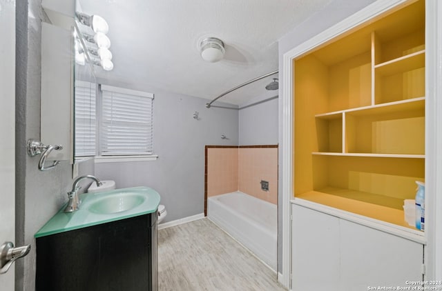 full bathroom with tub / shower combination, vanity, a textured ceiling, wood-type flooring, and toilet