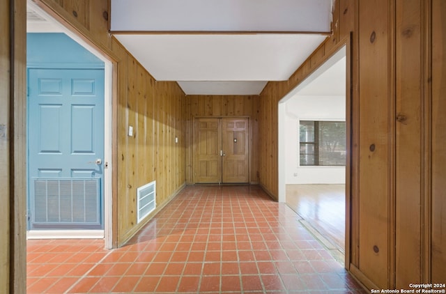 corridor featuring wooden walls