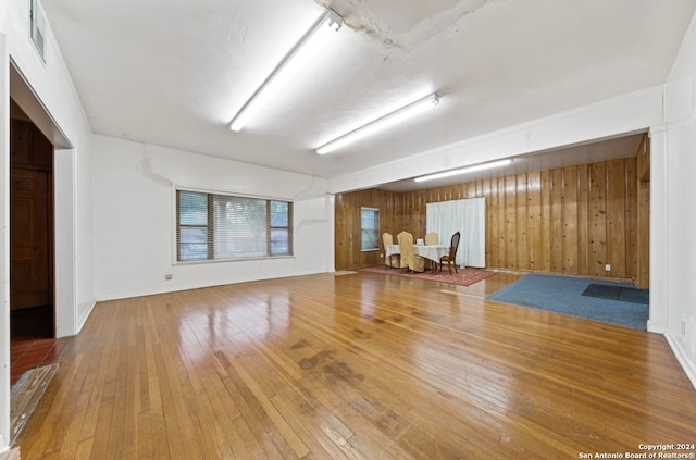 unfurnished room with hardwood / wood-style flooring and wood walls