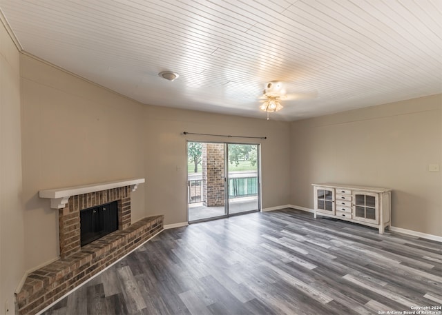 unfurnished living room with ceiling fan, a fireplace, and dark wood-type flooring