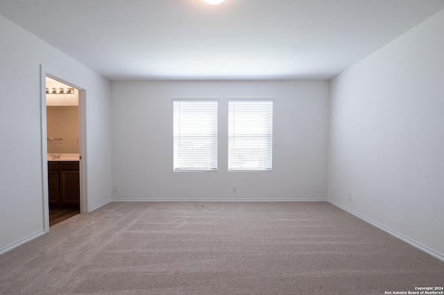 unfurnished room featuring light carpet