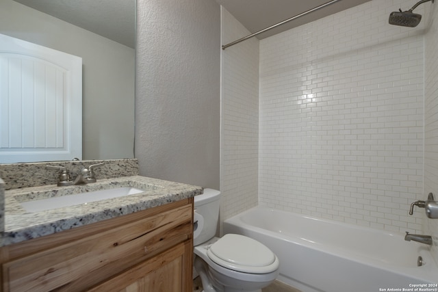 full bathroom featuring vanity, tiled shower / bath combo, toilet, and a textured ceiling