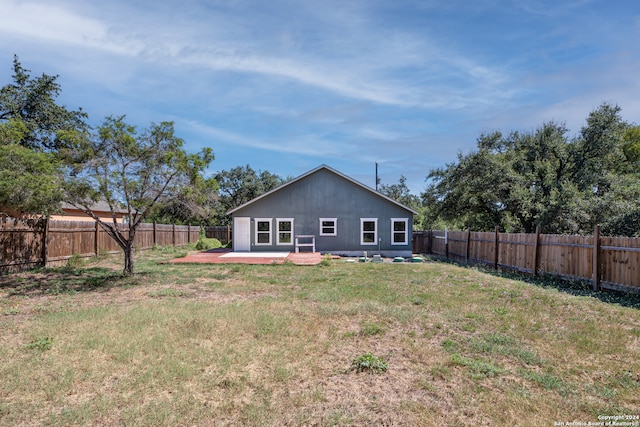 rear view of property featuring a yard and a patio