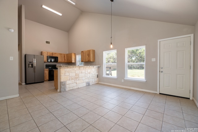 kitchen featuring pendant lighting, black appliances, kitchen peninsula, and light tile patterned floors