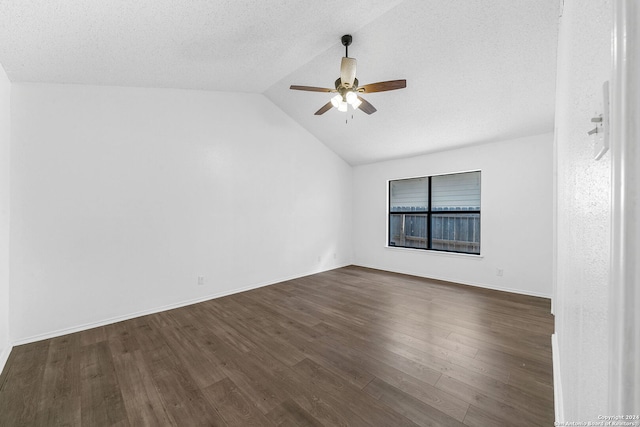 spare room with a textured ceiling, dark hardwood / wood-style flooring, ceiling fan, and lofted ceiling