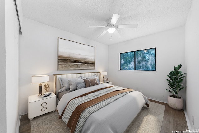 bedroom with ceiling fan, light hardwood / wood-style floors, and a textured ceiling