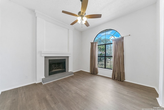 unfurnished living room with hardwood / wood-style floors, a textured ceiling, and ceiling fan