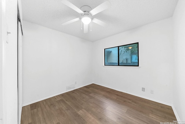 unfurnished room with ceiling fan, wood-type flooring, and a textured ceiling