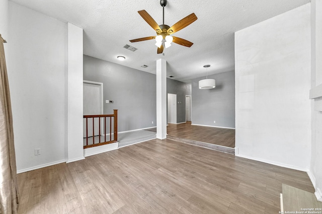 empty room with hardwood / wood-style floors, a textured ceiling, and ceiling fan