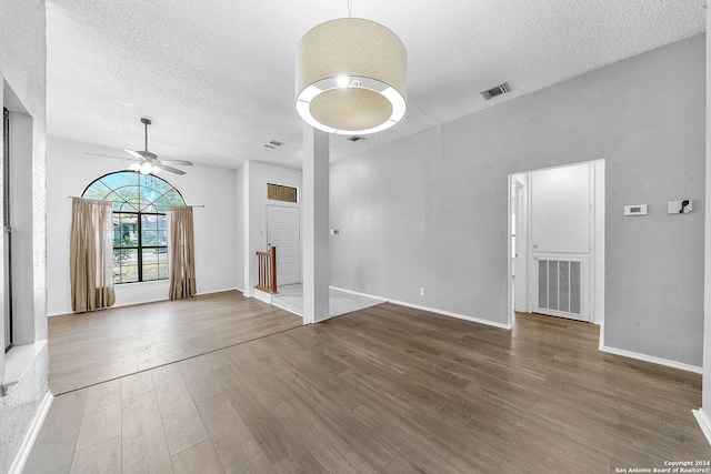 unfurnished living room with ceiling fan, a textured ceiling, and hardwood / wood-style flooring