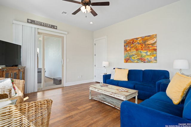 living room featuring dark hardwood / wood-style flooring and ceiling fan