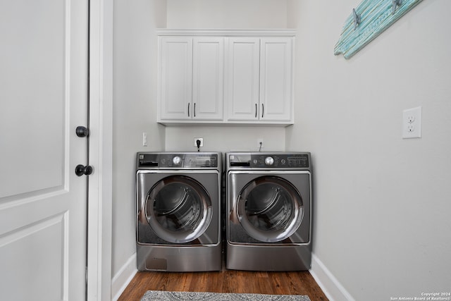 washroom with cabinets, dark wood-type flooring, and washer and dryer