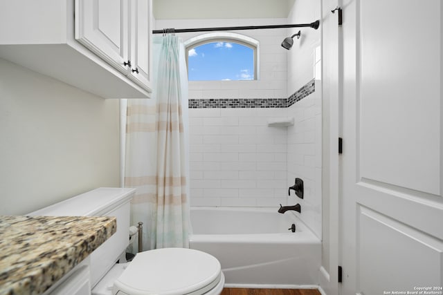 bathroom with shower / bathtub combination with curtain, hardwood / wood-style flooring, and toilet