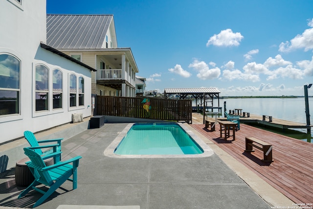 view of swimming pool with a patio and a water view